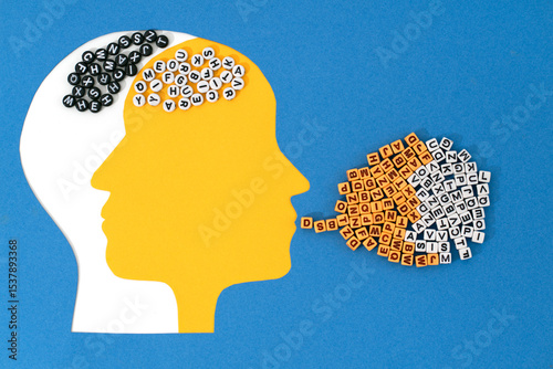 Two intersecting paper-cut heads, white and yellow, with contrasting letter patterns in the brain area. A cloud of mixed letters flows from the white mouth, symbolizing the contrasting moods 