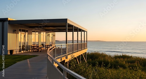 Modern architecture overlooking calm ocean at sunset with peaceful ambiance and beauty