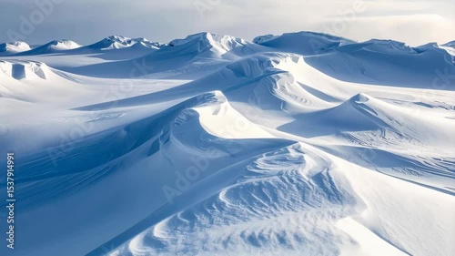 Abstract snowfield landscape featuring rolling hills and textured drifts under an overcast sky.