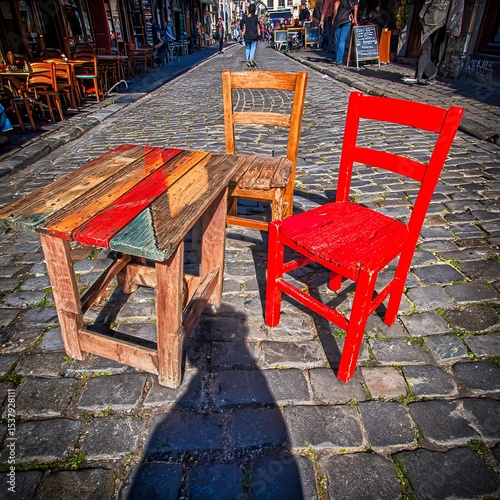 Colorful wooden table and chairs on a cobblestone street. photo