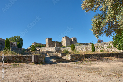 Trujillo Castle in Extremadura with its 9th-century defensive architecture surrounded by nature under an intensely blue sky