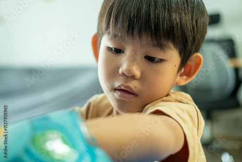 Asian boy reaching for a bag of candy