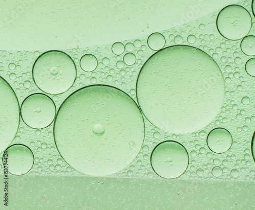Macro microscope green bubble texture, Close-up Green bubbles and drops oil background . blue green water bubbles, close up golden oil drop for cosmetic