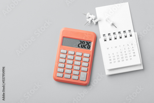 2026 Calendar with coral calculator and pins on gray background, tax payment, financial planning