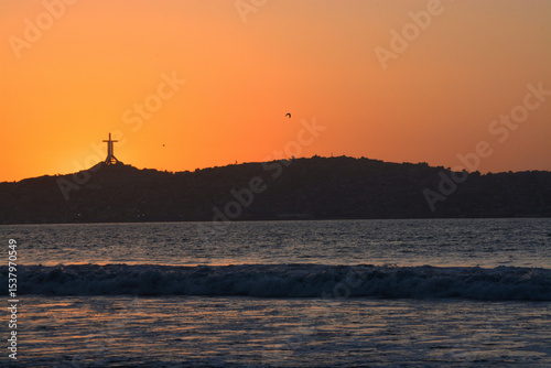 
Silhouette of the Third Millennium Cross at sunset in the sea from serene Chile