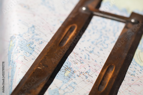 Vintage navigational instrument lying across a detailed nautical chart map