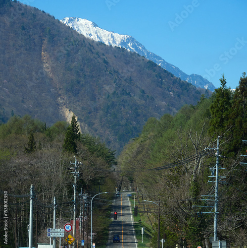 春の観光名所長野県の大町アルペンラインの農家と立山連峰の雪景色