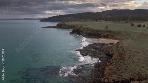 Aerial footage of Kelvedon Beach, Tasmania at sunrise. Captured after a night storm, the video shows moody skies, soft light, and serene coastal beauty in 4K.