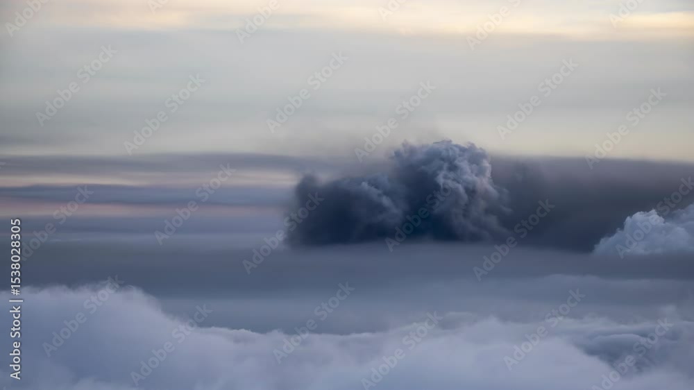 Dark cloud formation over a layer of fluffy clouds, showcasing atmospheric contrast