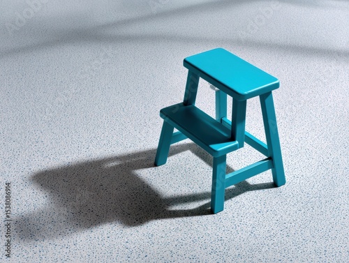 Blue step stool is sitting on a grey floor
