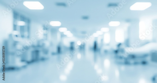 Blurred hospital interior with beds and medical equipment in a light blue setting.