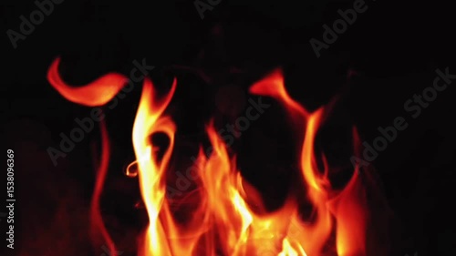 Realistic animated fire on a black background, with glowing orange and yellow flames, flickering movement, rising smoke, and floating embers. Cinematic lighting, smooth animation, high detail.