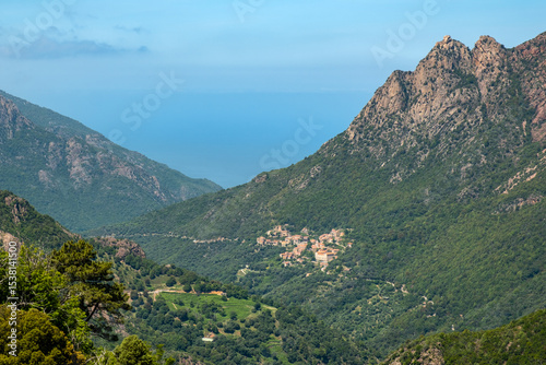 The village of Ota near the west coast of the island of Corsica with the towering peak of Capu d'Ota behind and the Mediterranean sea in the distance