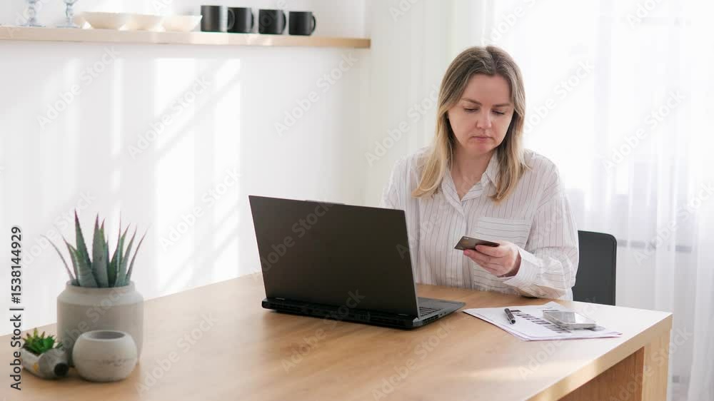 Young woman pays for online training using bank card directly laptop without leaving home. On laptop, female enters data confirms payment. Paying with laptop way to resolve financial issues of home. Young woman pays for online training using bank card directly laptop without leaving home. On laptop, female enters data confirms payment. Paying with laptop way to resolve financial issues of home.