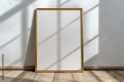 A gold-framed blank canvas stands against a textured wall, bathed in sunlight streaming through a window, casting dramatic shadows on the floor and frame