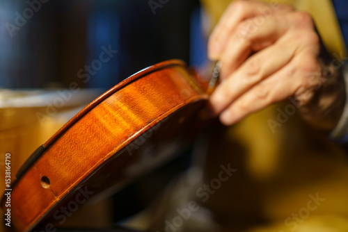 Fotografie Skilled craftsman carefully assembling violin components, showcasing intricate w