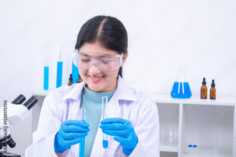 Fototapeta premium Scientist girl in lab coat observing chemical substance with care during experiment. Science, laboratory, scientist, experiment, and research represent discipline and education, healthcare.