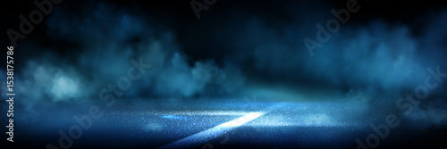 Blue lit asphalt road with white marking in smoke clouds. Night race atmosphere with glowing pavement surface on dark bg. Dramatic fog effects in mysterious street scene for auto or speed competition.