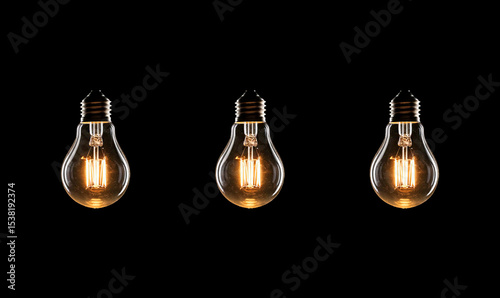 Electric incandescent lamp shines in the dark. Source of light. Symbol of idea. Many light bulbs on a black background