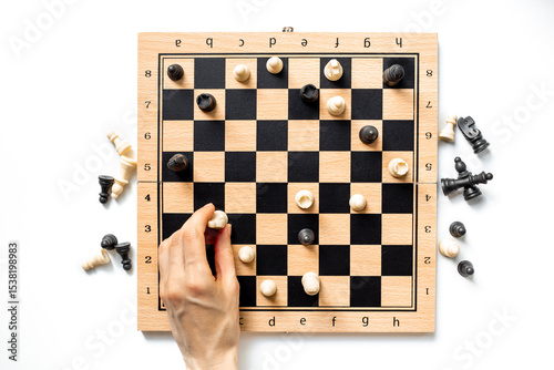 Hand is holding chess piece on chessboard. Game concept