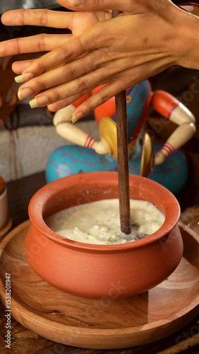 Traditional way of making buttermilk in village using traditional equipment photo