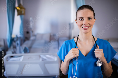 Rows of hospital beds standing in bright ward with IV stands and blue curtains, copy space