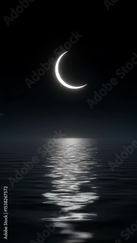 Crescent moon reflecting on dark water surface at night  