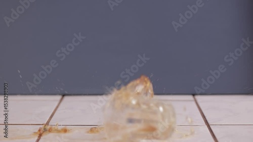 Glass of soft drink coke hitting the ground breaking