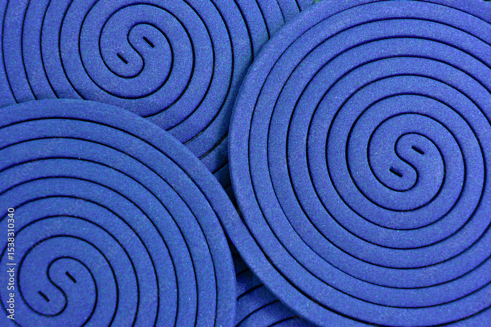 Obraz premium The arrangement of blue cobalt mosquito coils creates a distinctive, repeating circular patter green spiral background, resembling a yin-yang symbol