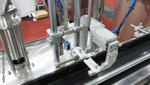 An automated capping machine on a conveyor belt.For high speed bottle and container packaging.