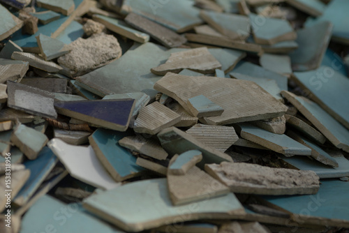 A disorganized pile of broken tiles is currently sitting scattered on the ground, creating quite the mess for anyone nearby to see