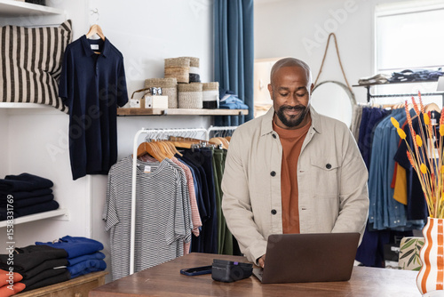 Shopkeeper engaged while working at his computer