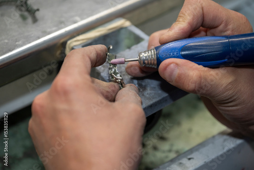 main d'un laborantin passant une fraise sur une stellite dentaire