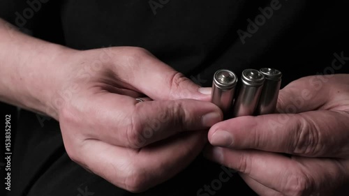 close-up of hands holding rechargeable batteries
