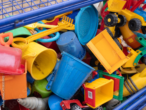 Kinderspielzeug für den Sandkasten im Kindergarten in Nahaufnahme in einer Blauen Gitterbox in Nahaufnahme