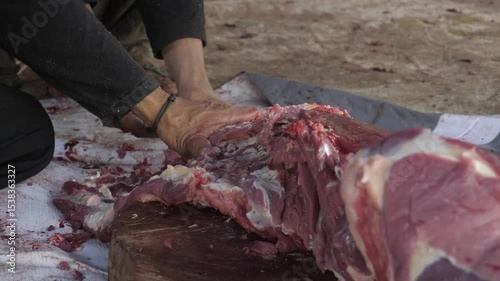 close up of a man's hand cutting meat with a knife