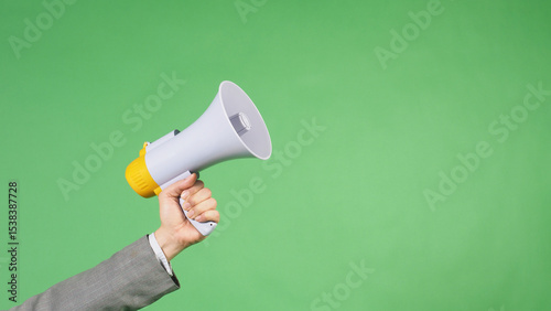 Hand is hold megaphone and wear grey suit on green screen background.