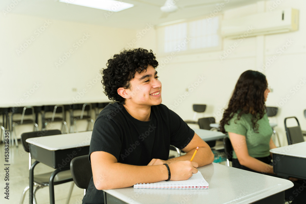 Fototapeta premium Happy high school student taking notes in classroom