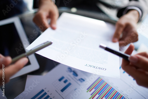 Professional Business Contract Review: Hands-on Collaboration with Documents, Pens, and Charts in Office Setting