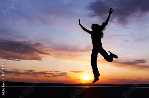 One young girl enjoys her vacation at sunset. Silhouette.