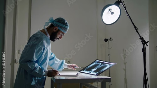 Surgeon analyzing x ray images on a laptop in hospital room