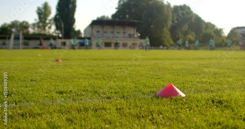 The video vividly shows an engaging and dynamic soccer training session taking place on a vibrant green field, where enthusiastic players actively practice their skills using colorful cones