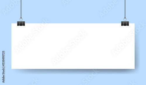 White sheet of paper note hanging on binder clip. Long wide banner with panoramic orientation. Light blue background