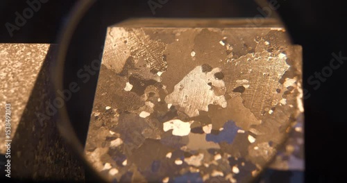 Sample of aluminum under magnifying glass with large grains, that froze very slowly. Structure of materials, including grain size, often depends on cooling rate from melting point or heat treatment
