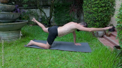 Modern man doing yoga balance pose outdoors