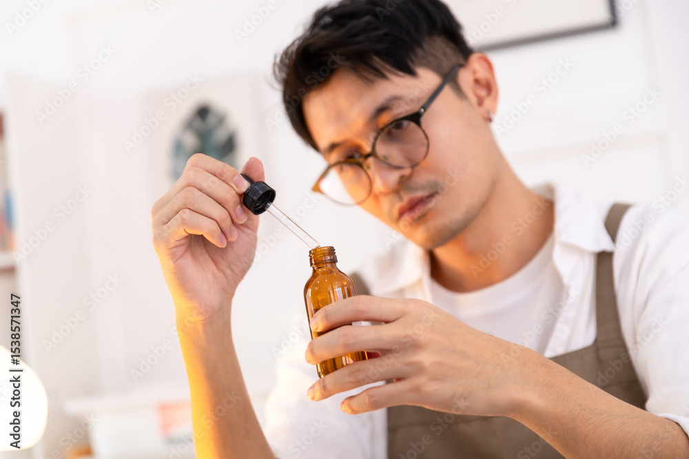 Fototapeta premium The man is carefully and intently examining the product in his bottle.