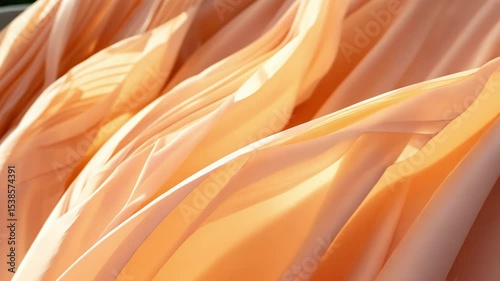 Elegant folds of light pink fabric create luxurious, flowing abstract texture	