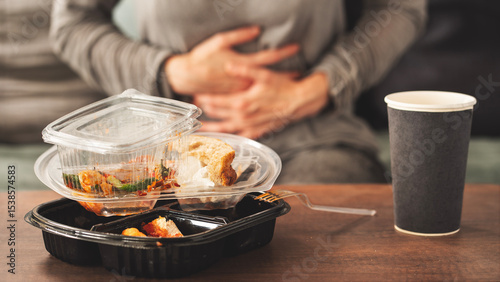 Woman with bloating and stomach pain after fast food meal
