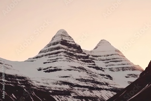 Snow-capped mountain peaks at dawn with clear sky background