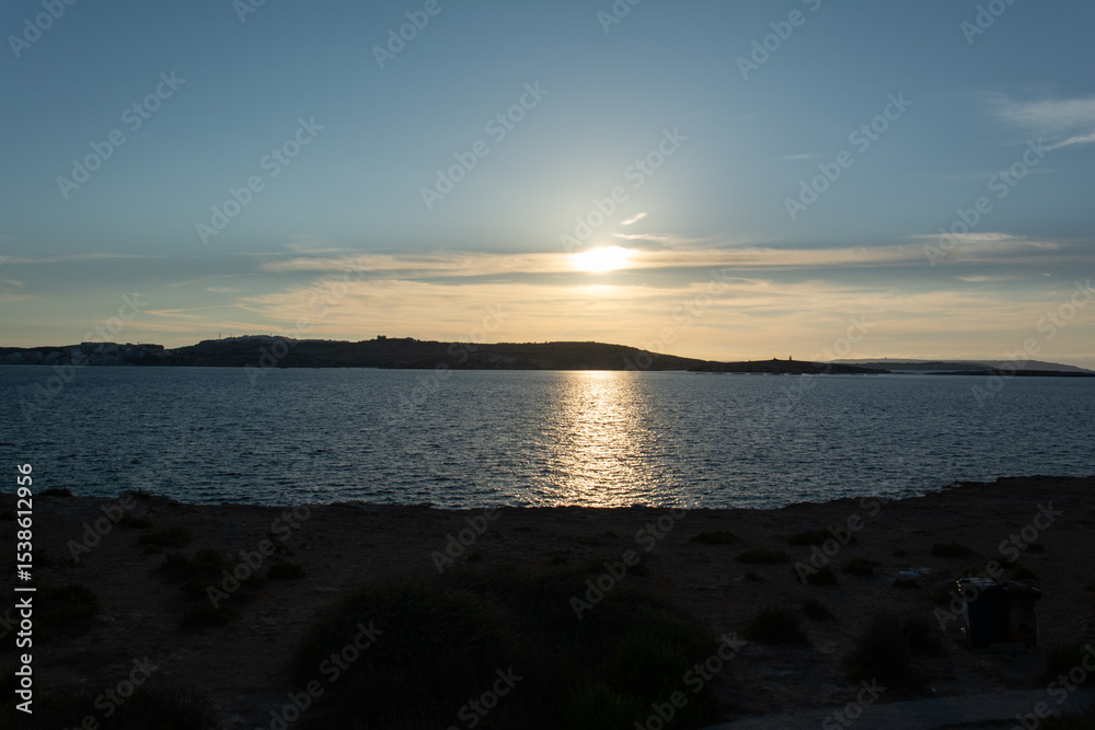 Naklejka premium Golden Light Over Coastal Landscape at Dusk